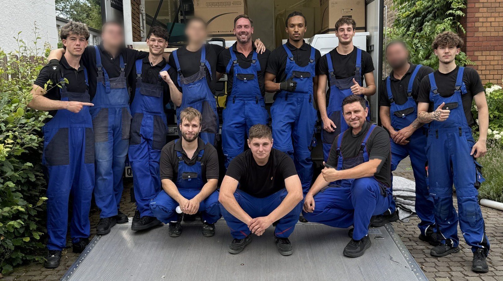Das Team der Umzugsunion vor der geöffneten Ladebordwand des Umzugswagens in Köln