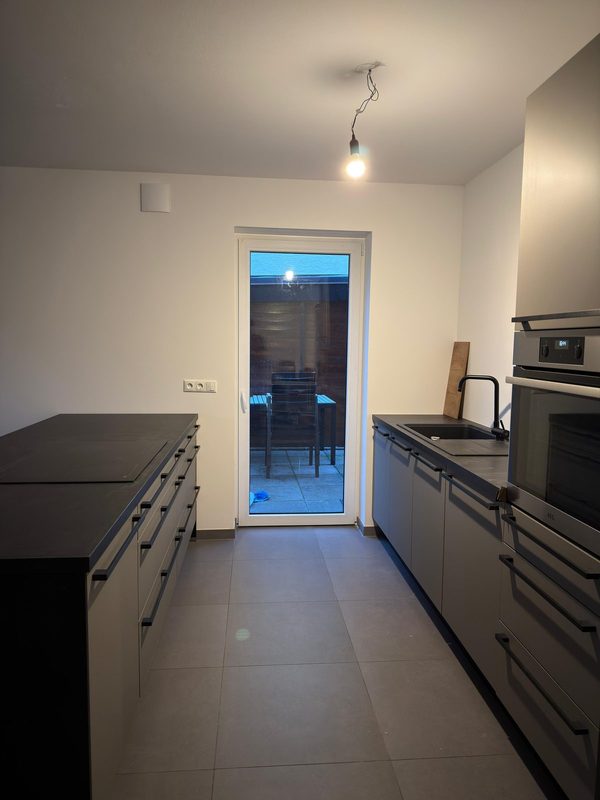 Fertig montierte Küchenzeile mit Kochinsel und eingebauten Geräten in einem Neubau