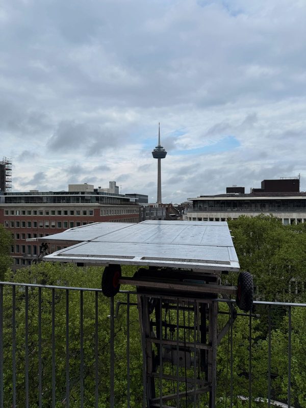 Plattform eines Möbellifts auf Höhe eines oberen Geschosses, im Hintergrund der Fernsehturm