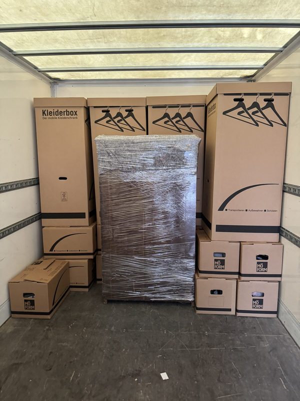 Laderaum mit aufgereihten Kleiderboxen und einem folierten Schrank in der Mitte
